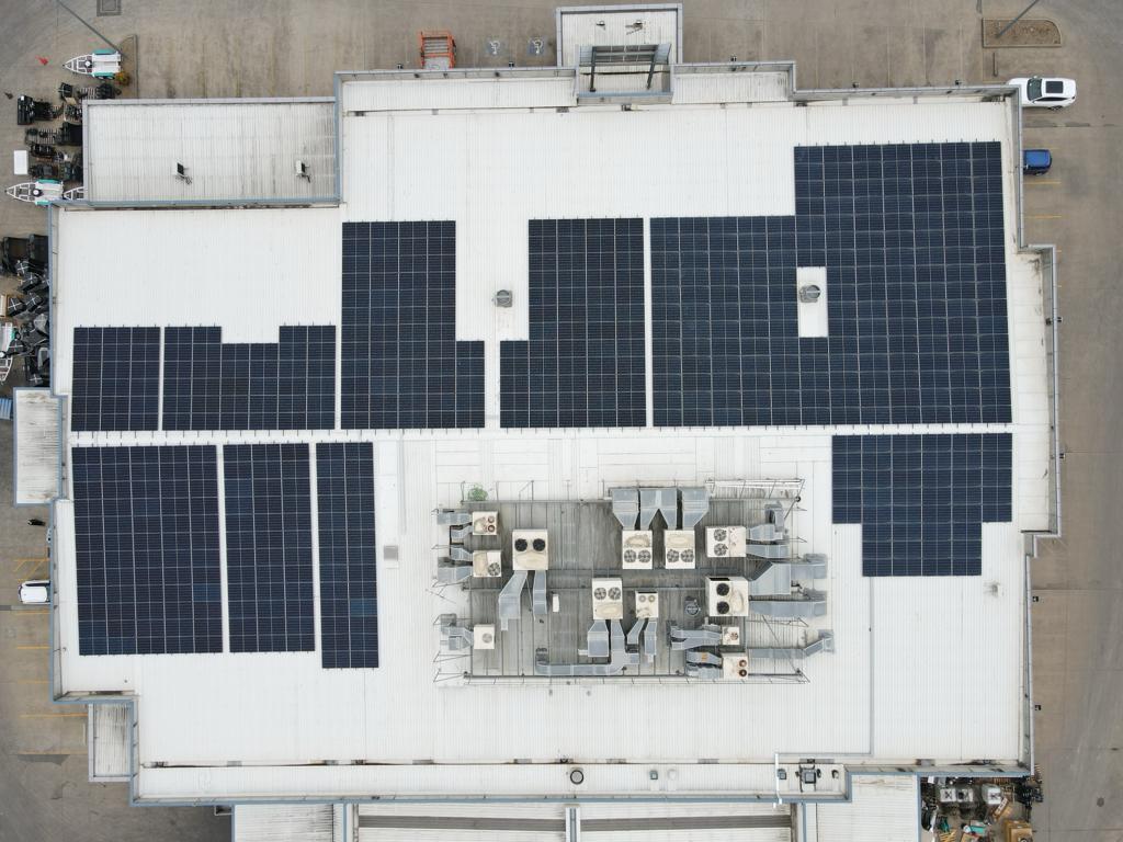 Aerial view of a large commercial rooftop solar installation